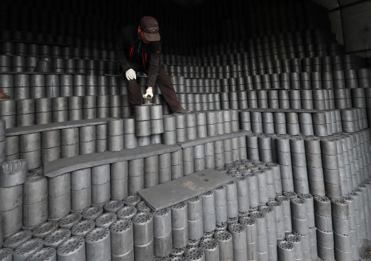 초겨울 추위가 찾아온 29일 오후 경기도 화성시의 한 연탄보급소에서 직원이 분주하게 연탄을 옮기고 있다.